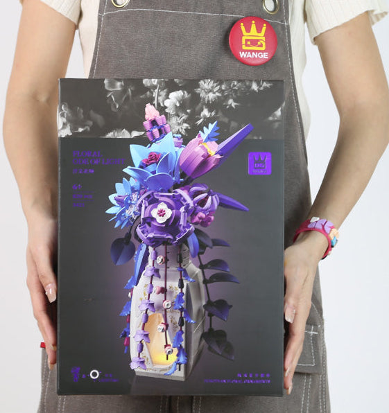 Person holding a product box with a colorful flower design on a white background